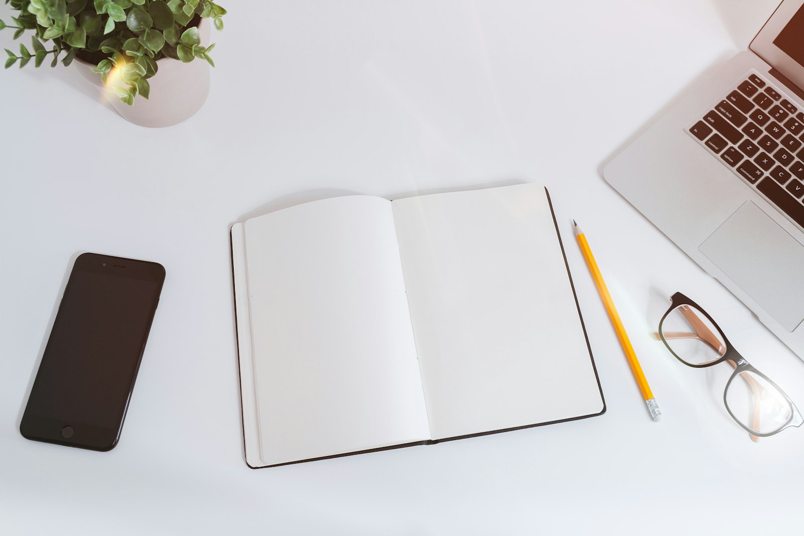 Organized desk with a planner, laptop and coffee representing daily administrative support