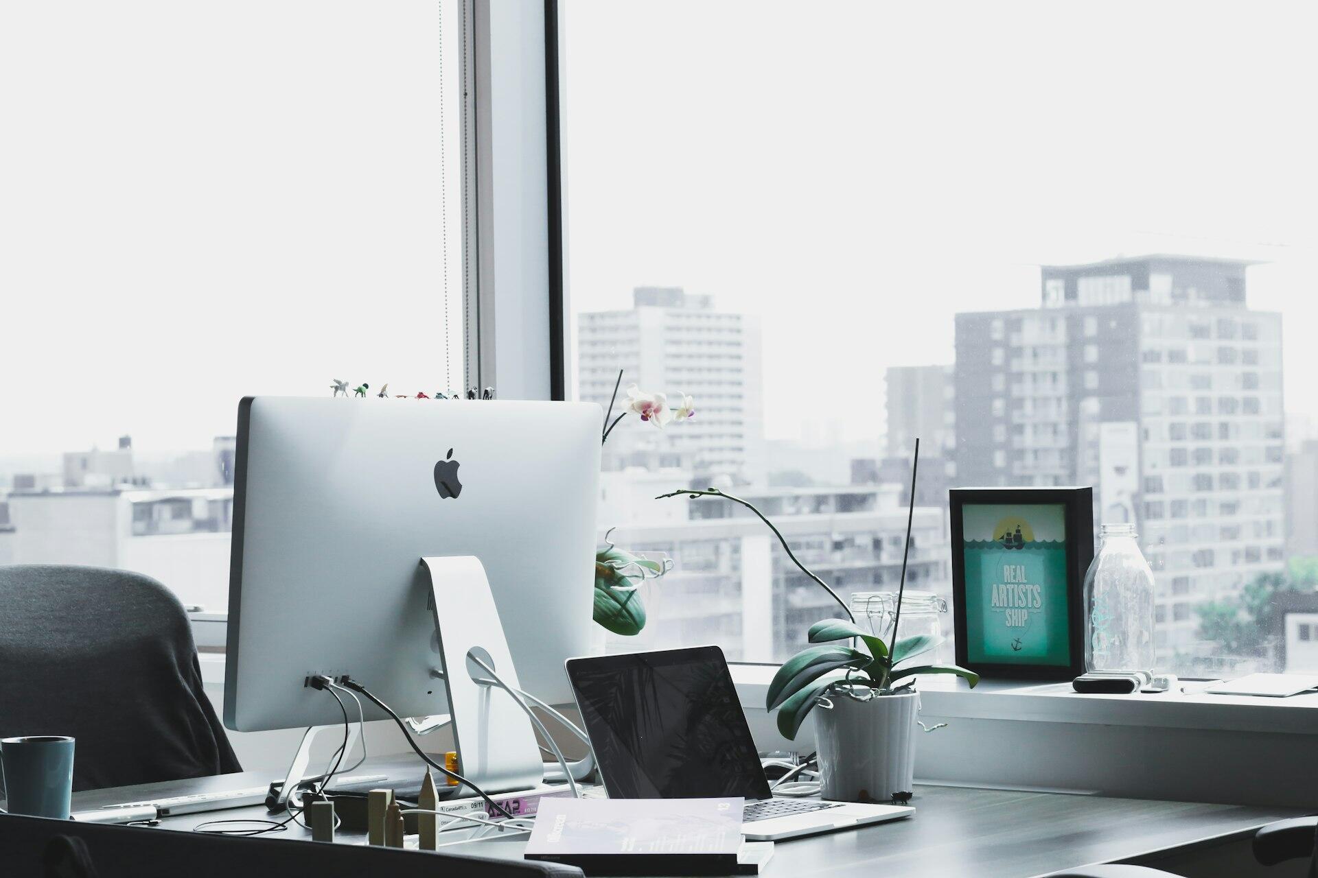 Bright office workspace with computers beside a city window
