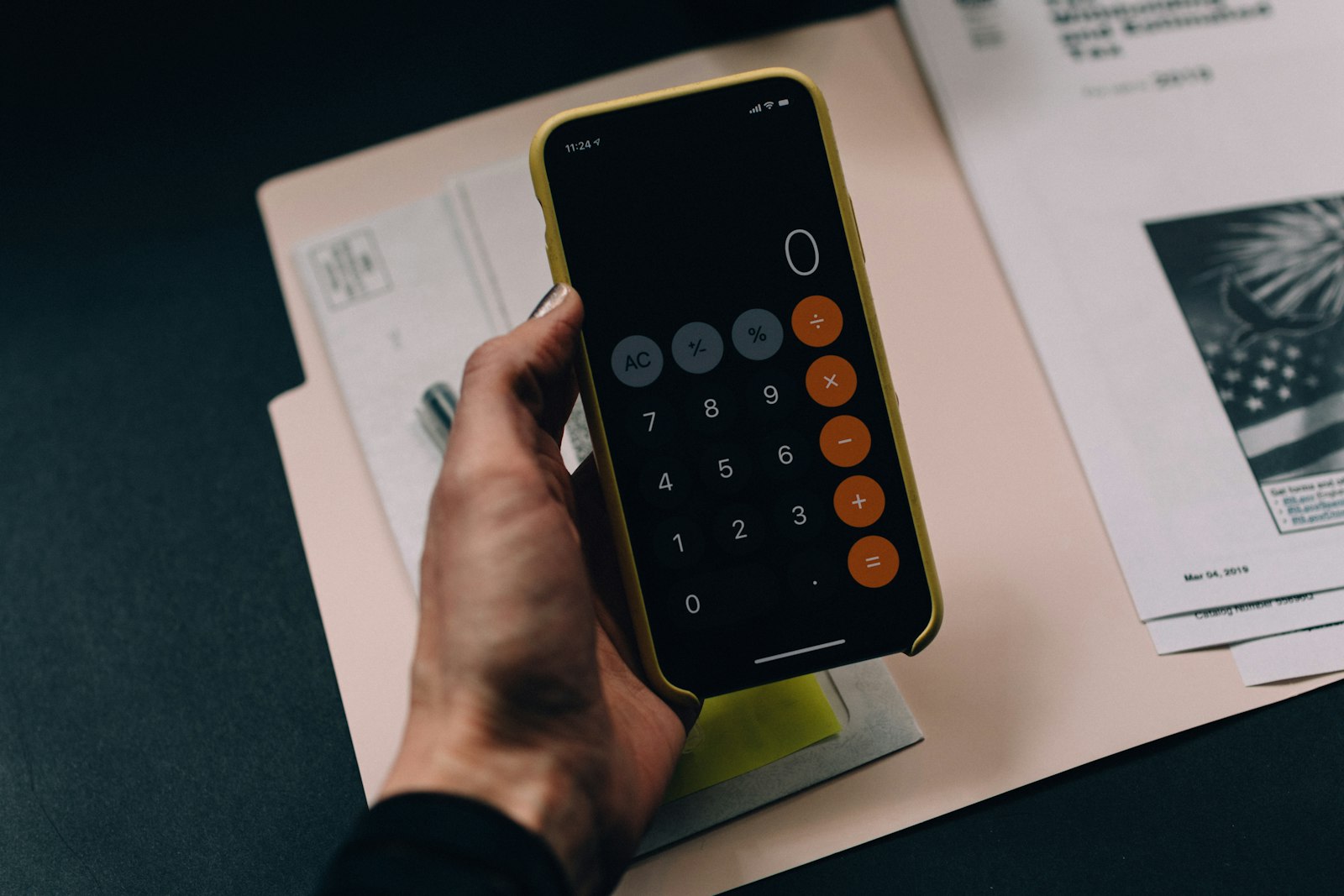 A hand writing support options in a planner next to a laptop and calculator